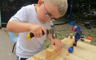 Image of a young boy using a hammer